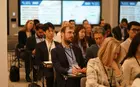 People sitting in rows of chairs, listening to a speaker outside the frame